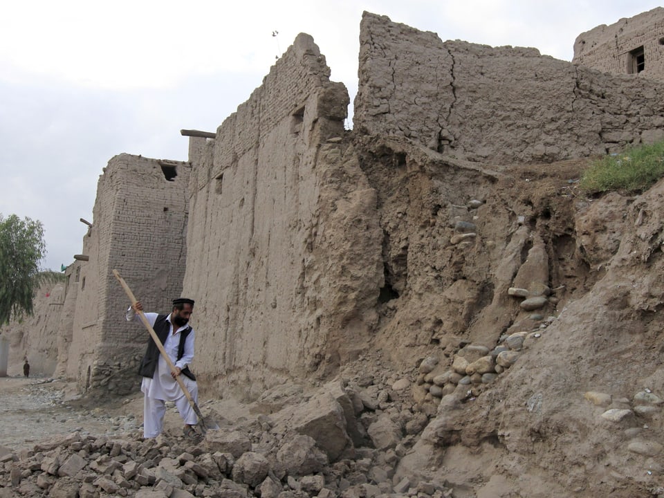  Ein Mann räumt in Jalalabad (Afghanistan) nach dem Beben den Schutt weg. 
