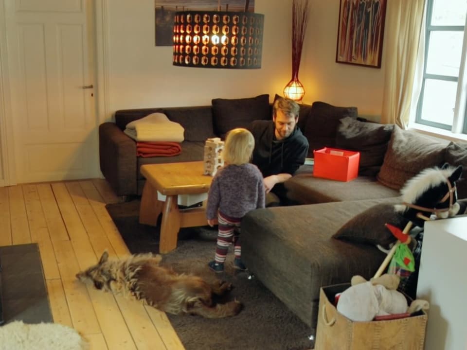 Ole mit Tochter und Hund im Wohnzimmer.