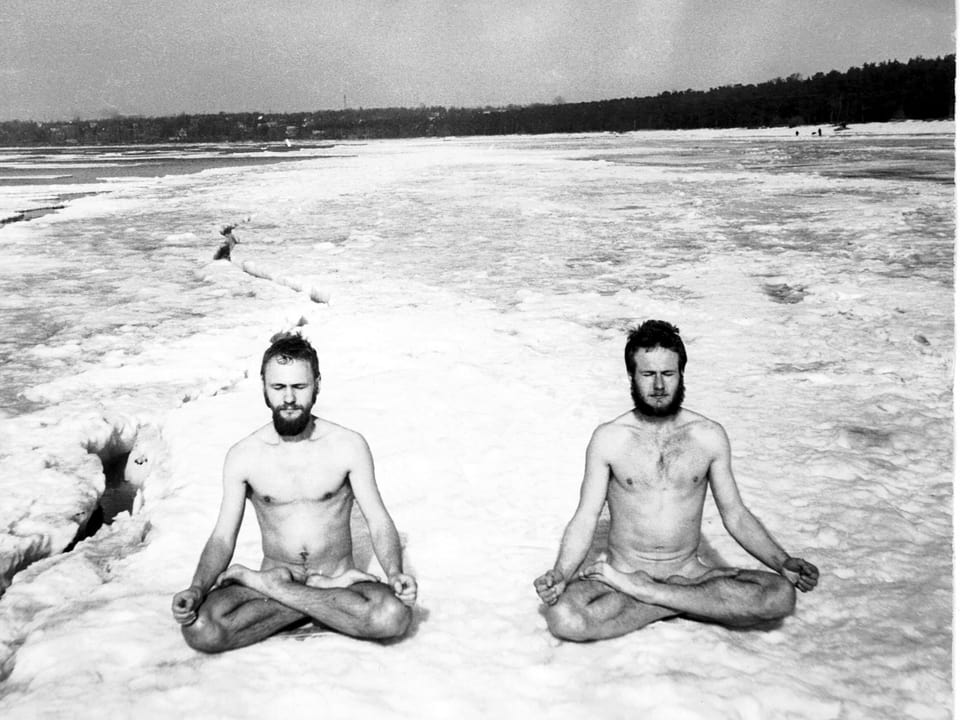 Zwei nackte Männer meditieren im Schneidersitz.