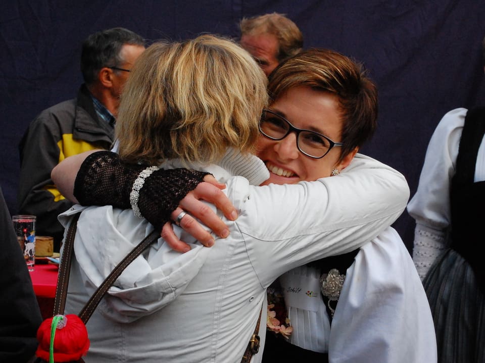 Zwei Frauen umarmen sich erfreut.