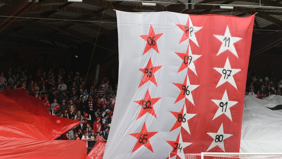 Die Sion-Fans mit einer Walliser-Flagge, auf der alle Jahreszahlen der Cupsiege in Sternen stehen