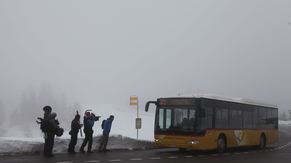 TV-Crew wartet im Nebel auf Postauto, welches soeben vorfährt. 