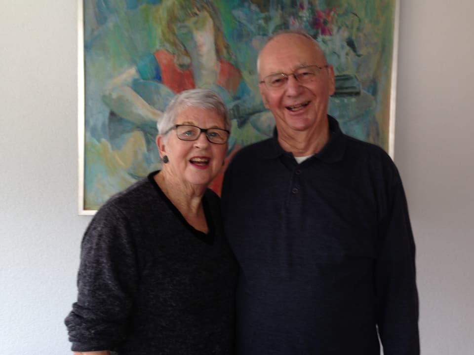 Das Ehepaar posiert in seiner neuen Wohnung vor einem Gemälde.