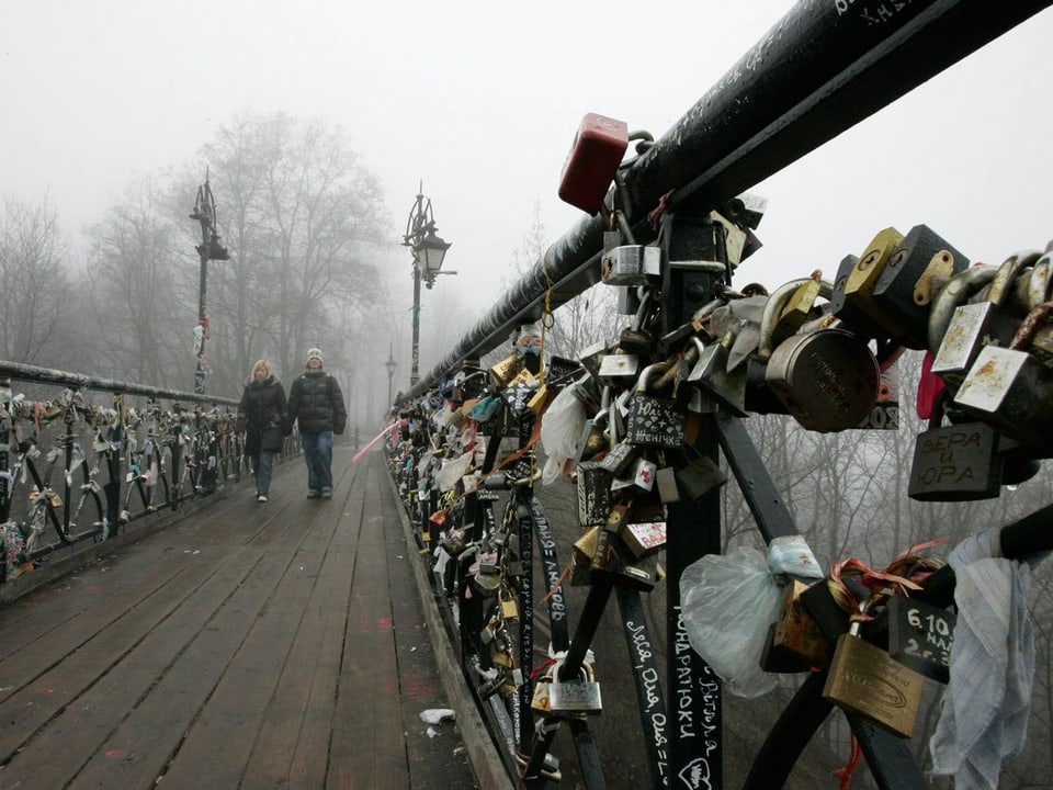 Brücke in Kiev im Nebel. Am Gelänger hängen Liebesschlösser.
