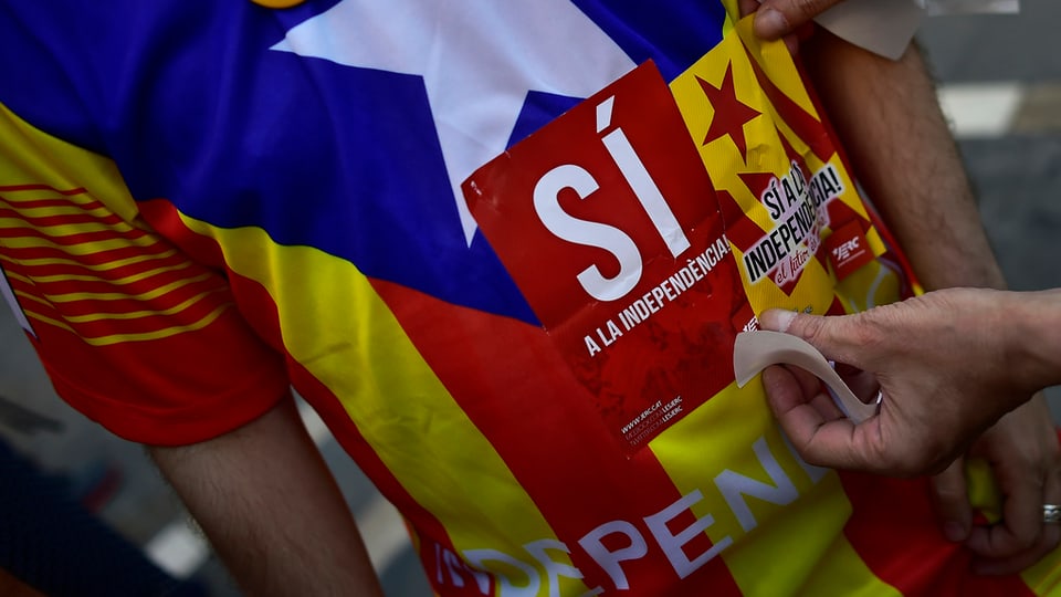 Person in T-Shirt mit katalonischer Flagge und dem Schriftzug Sí