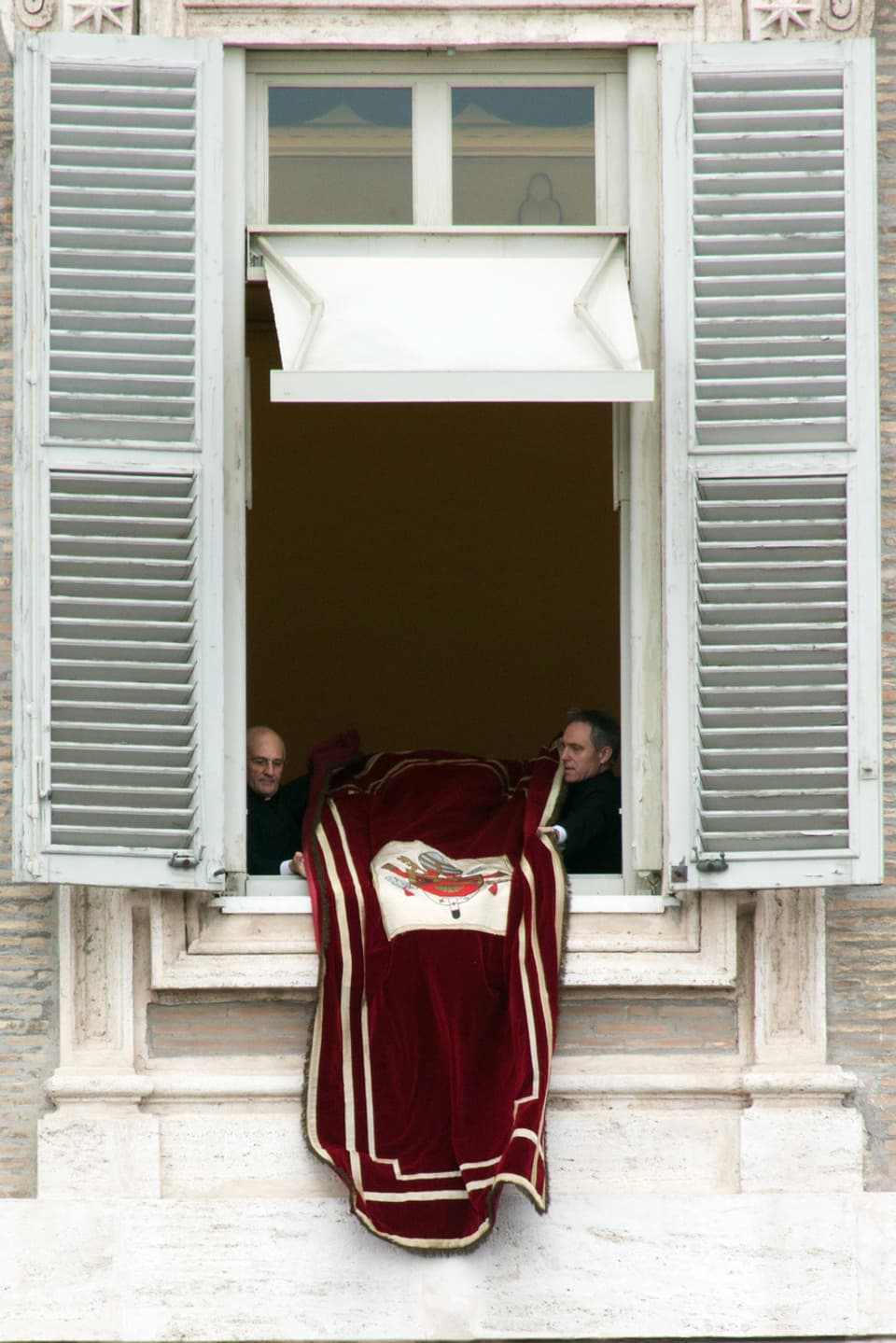 Der Privatsekretär des Papstes, Georg Gänswein (rechts), und ein namentlich nicht genannter Vatikan-Angestellter schliessen nach dem sonntäglichen Gebet das Fenster zum Arbeitszimmer des Papstes wieder. 