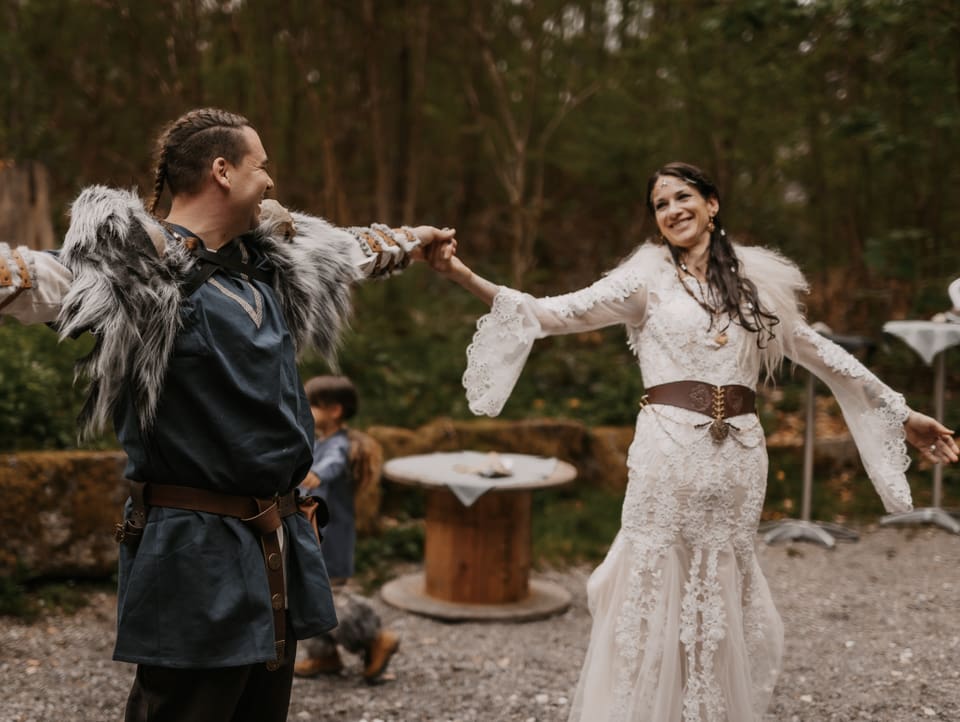 Ein Paar in keltischen Outfits beim Tanz in der freien Natur.