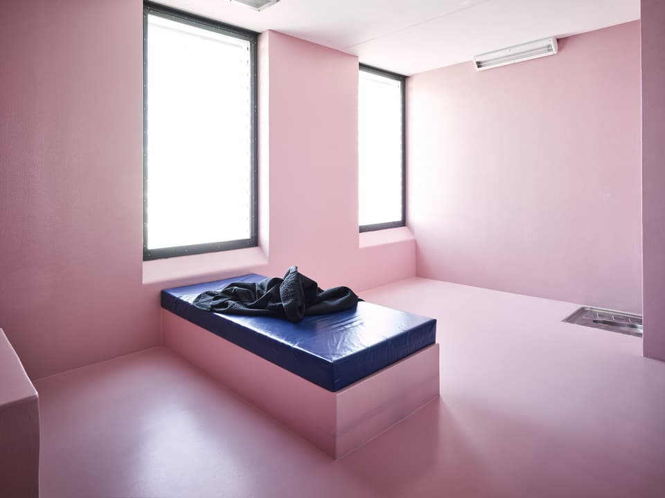 Eine pinkfarbene Gefängniszelle.