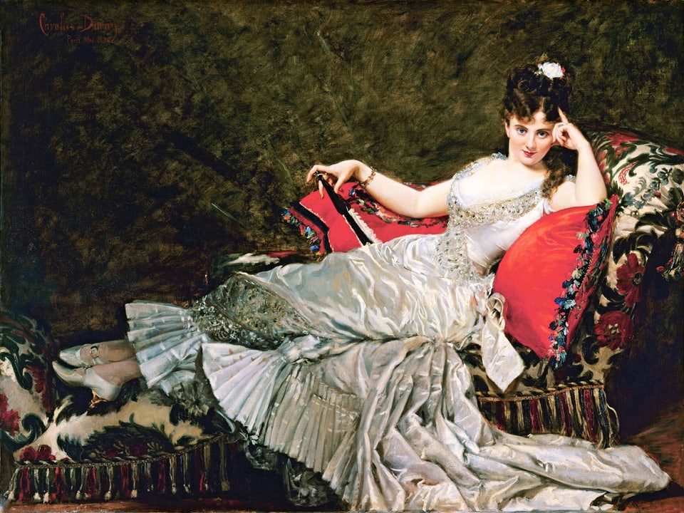 Dame in rauschendem Kleid sitzt auf einem Divan.