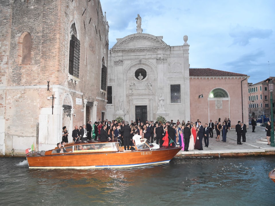 Eine Hochzeitsgesellschaft steht in der Alstadt Venedigs.