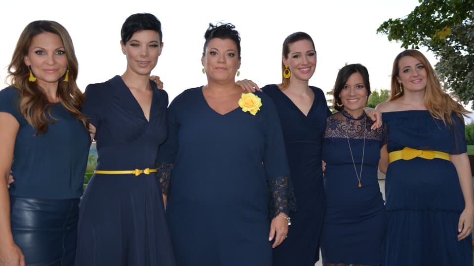 Sechs Powerfrauen mit farblich abgestimmten Kleidern.