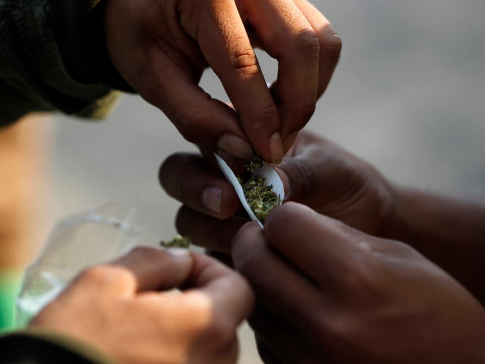 Hände drehen Cannabis-Joint