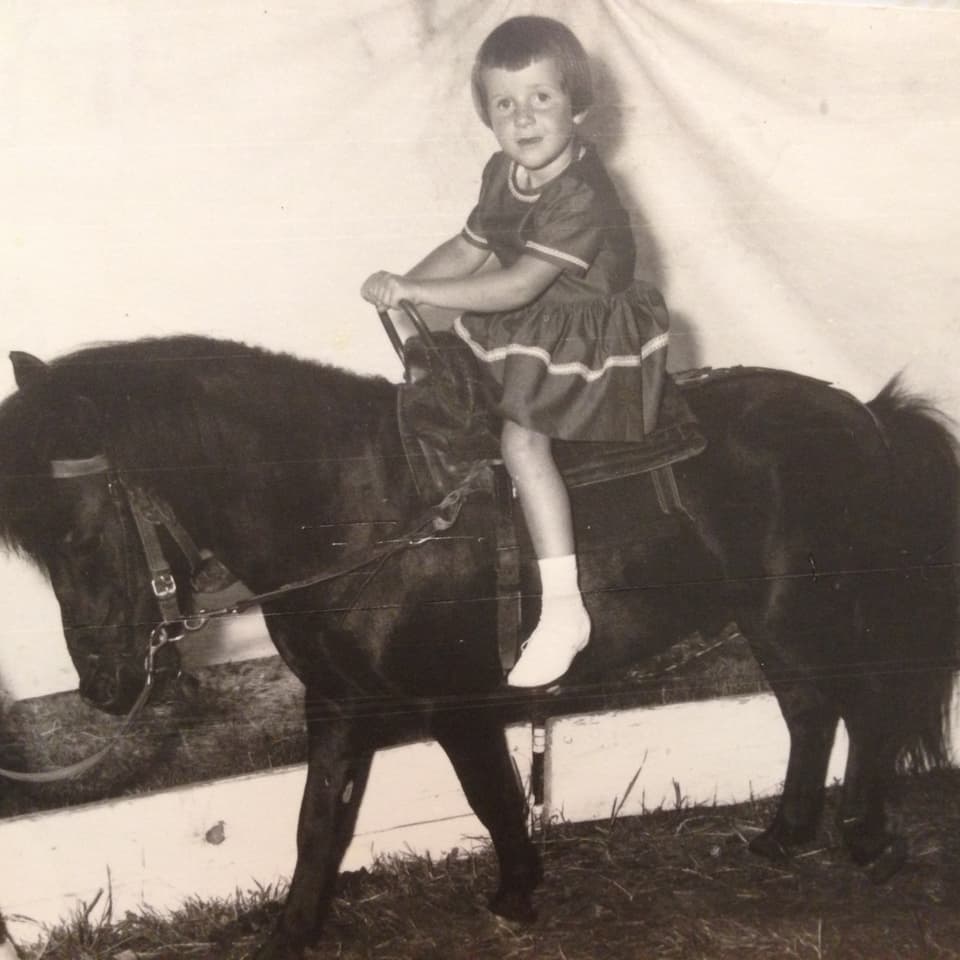 Ein Mädchen sitzt auf einem Pony.