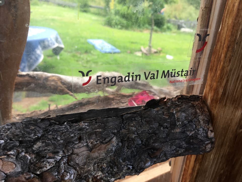 .Blick aus einem Fenster mit der Aufschrift 'Engadin Val Müstair'