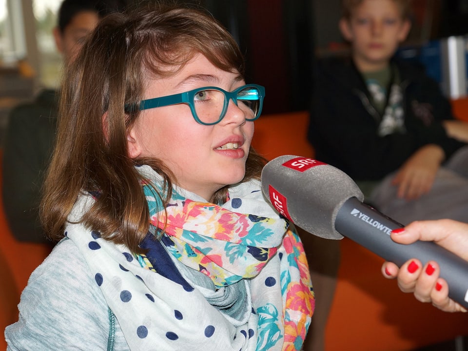 Ein Mädchen spricht ins Mikrofon.