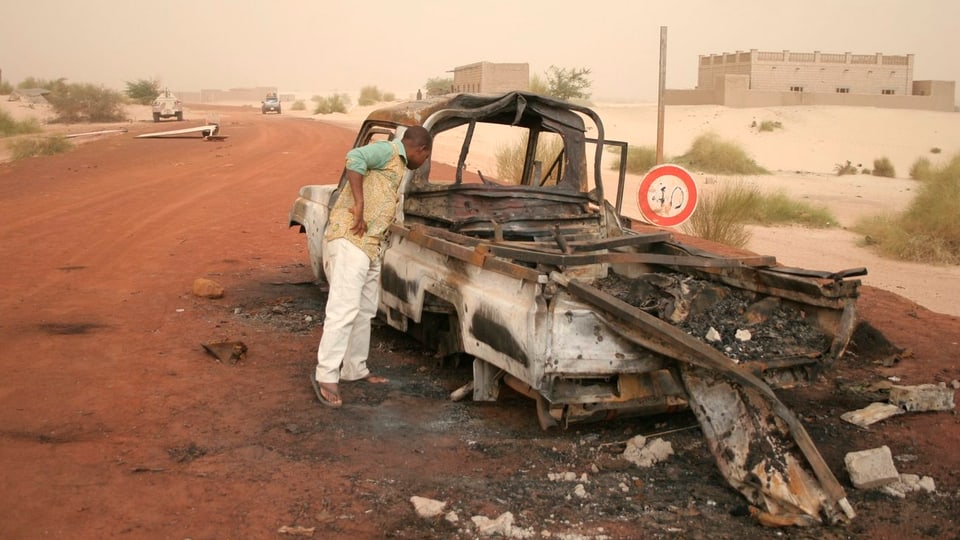 Ein ausgebrannter Pritschewagen am Strassenrand in Mali.