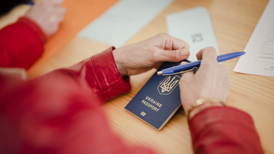 Eine Person hält einen ukrainischen Pass in den Händen.