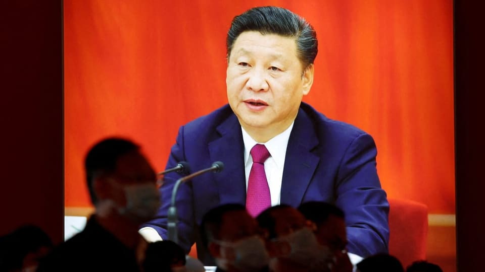 Xi Jinping auf einer grossen Leinwand. Er spricht im Anzug.