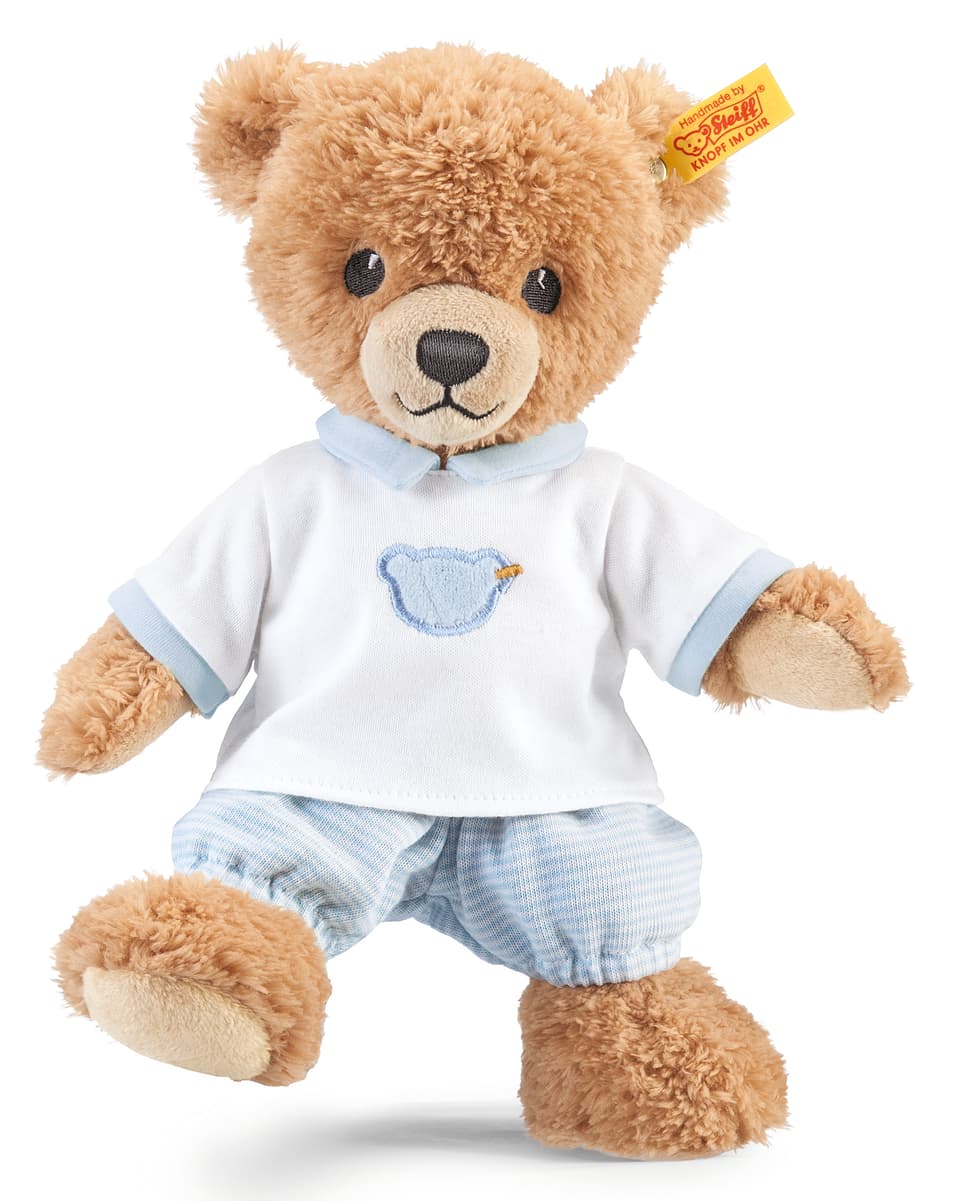 Ein Teddy-Bär mit blauer Hose und weissem Hemd.