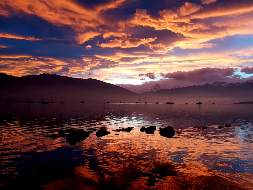 Das Morgenrot spiegelt sich in einem See.