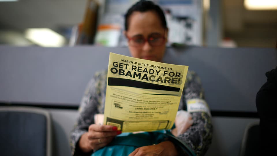 Eine Person studiert einen Obamacare-Flyer.