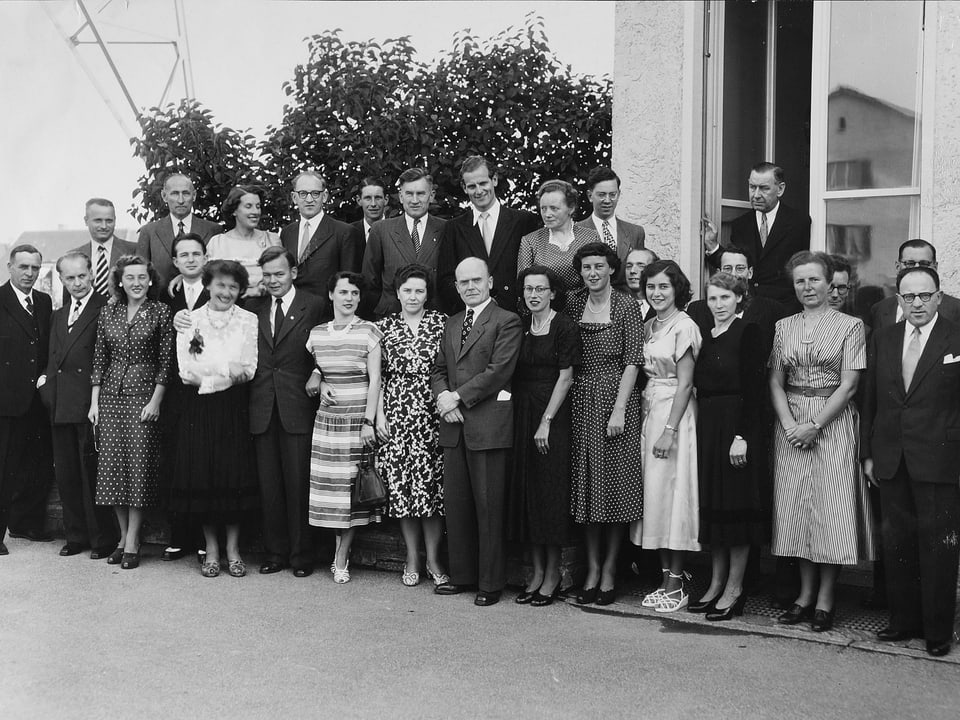Etwa 30 Männer und Frauen stehen vor dem Radiostudio Brunnenhof in Zürich im Jahr 1949.