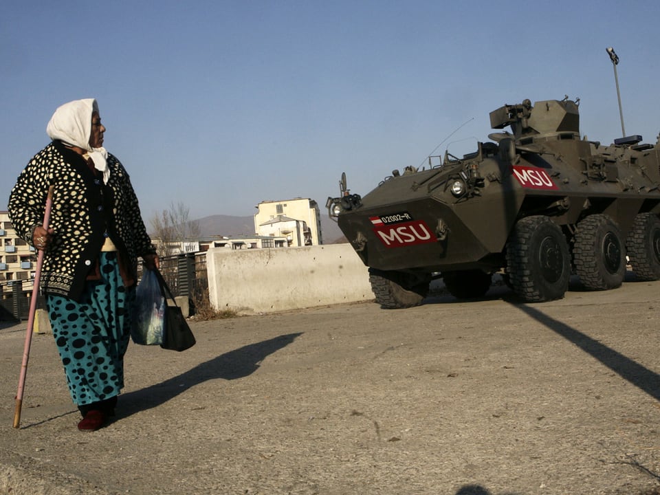 Kosovo-Albanische Frau vor Panzer 