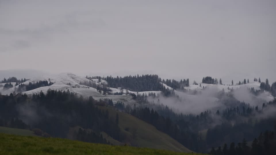 Leicht verschneite Hügelzüge im Emmental.