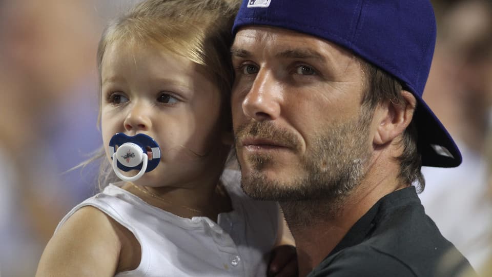 David Beckham trägt seine Tochter Harper auf dem Arm
