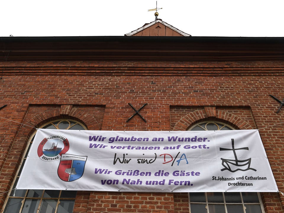 Auf einem Banner an der örtliche Kirche in Drochtersen steht: «Wir glauben an Wunder».