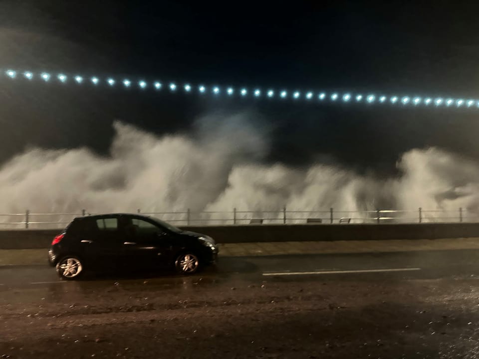 In Grossbritannien wird ein Fahrzeug von einer Brise, verursacht von einer hohen Welle, überrascht.