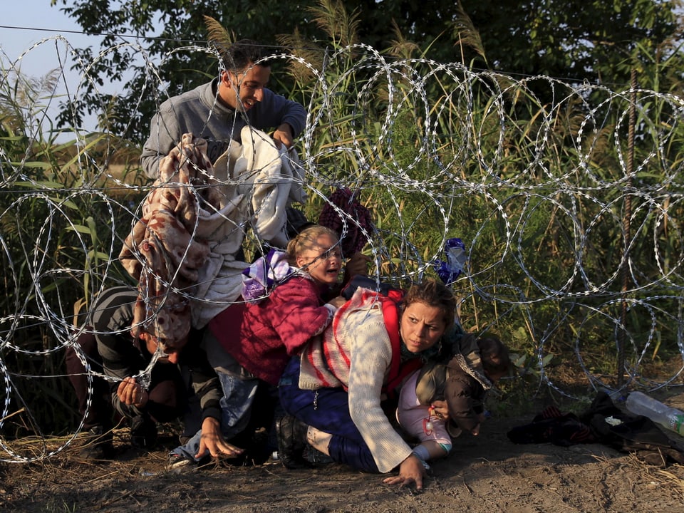 Syrische Flüchtlinge im Sommer 2015 bei einem Zaun an der serbisch-ungarischen Grenze.