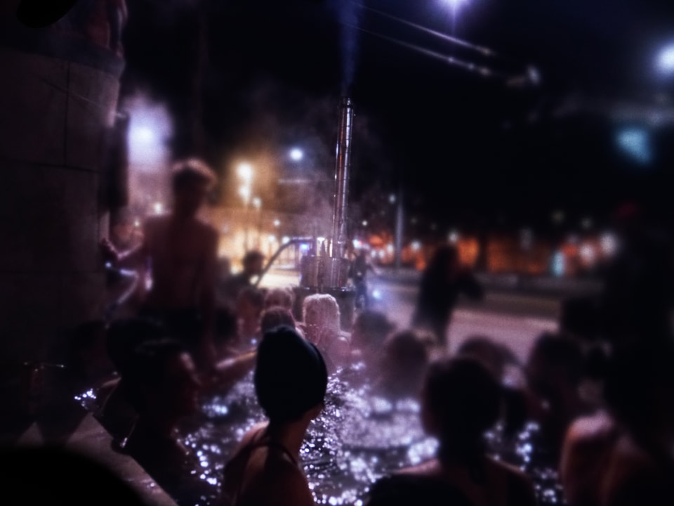 Menschen baden in einem Brunnen.