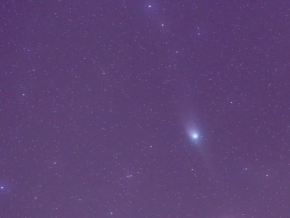 Violetter Nachthimmel mit hellen Sternen und einem grösseren Kometen