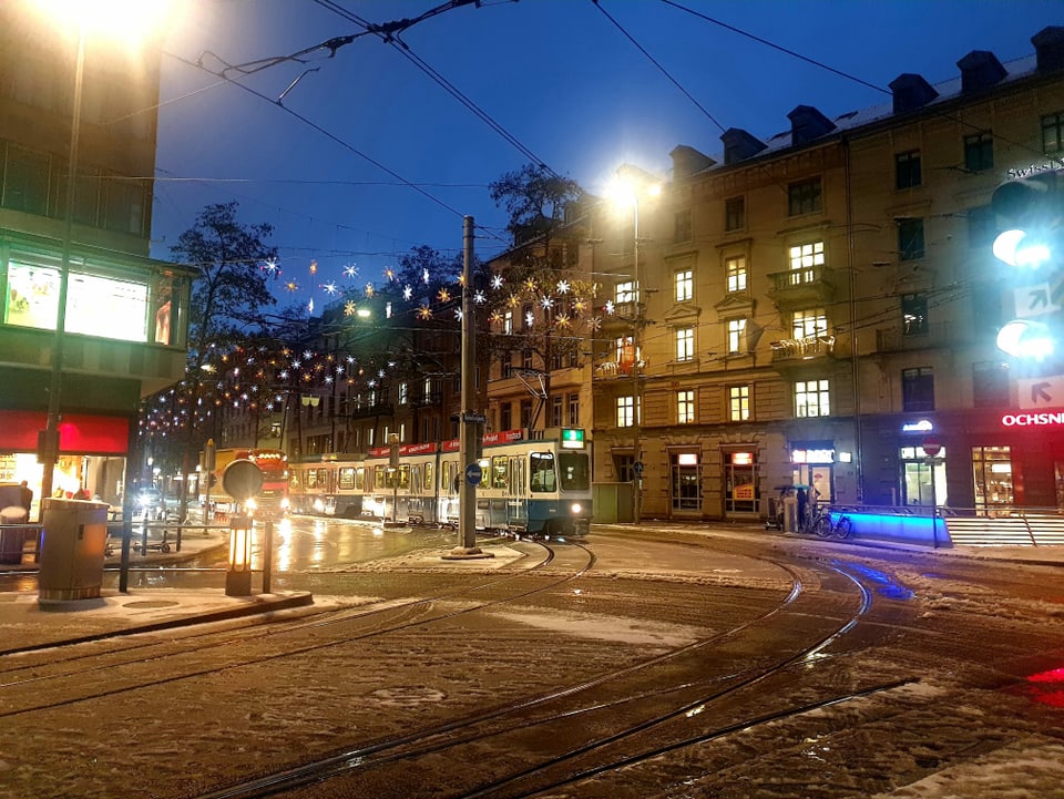 Blick auf eine verschneite Tramhaltestelle in der Stadt Zürich.