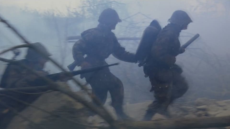 Soldaten rennen durch ein Schlachtfeld.