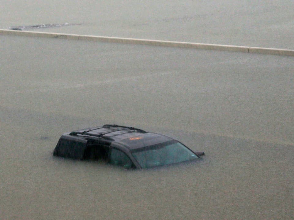 Ein Auto steht bis zum Dach im Wasser.