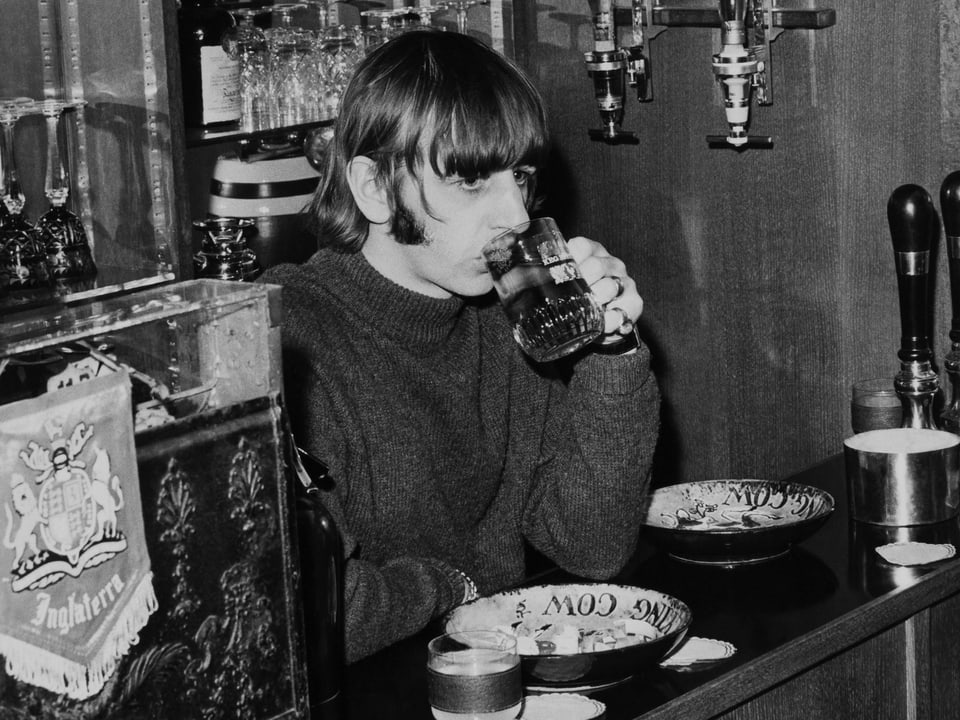 Bild von Ringo, wie er Bier an einer Bar trinkt. Er schaut dabei ins Leere.