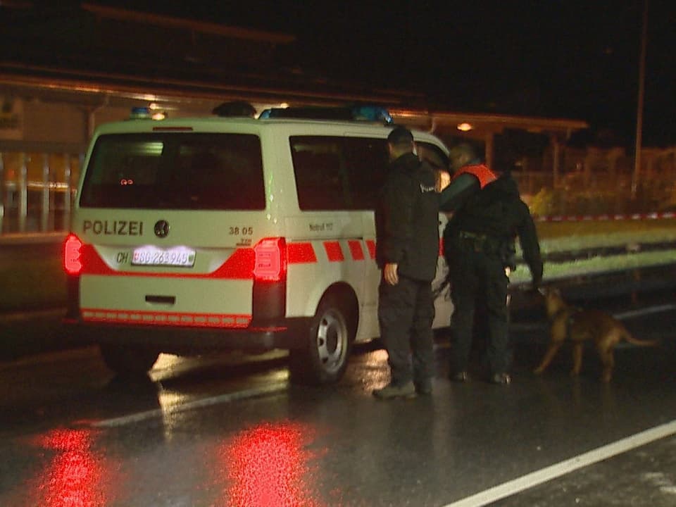 Polizeifahrzeug mit zwei Polizisten und einem Hund.