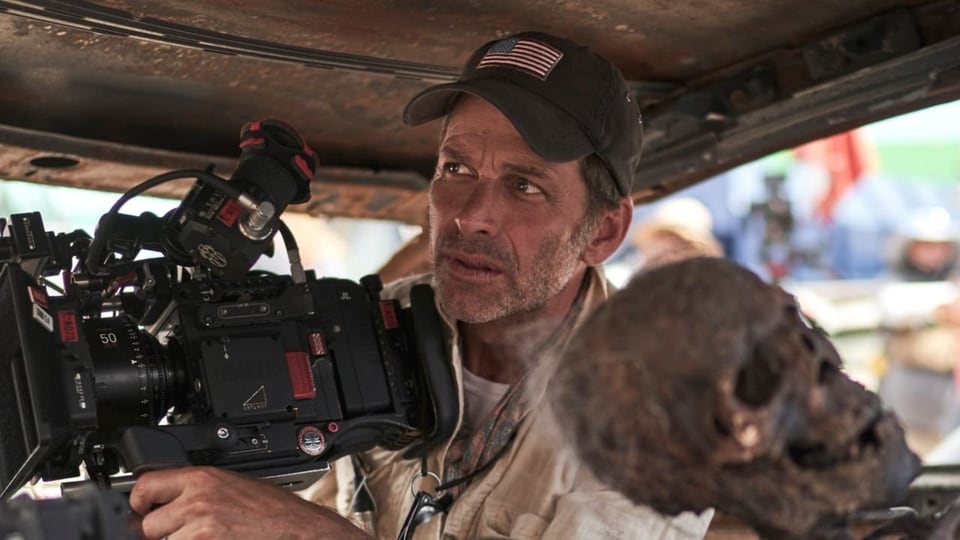 Regisseur Zack Snyder am Set, in einem Wagen, mit einer Kamera. Im Vordergrund ein Skelett.