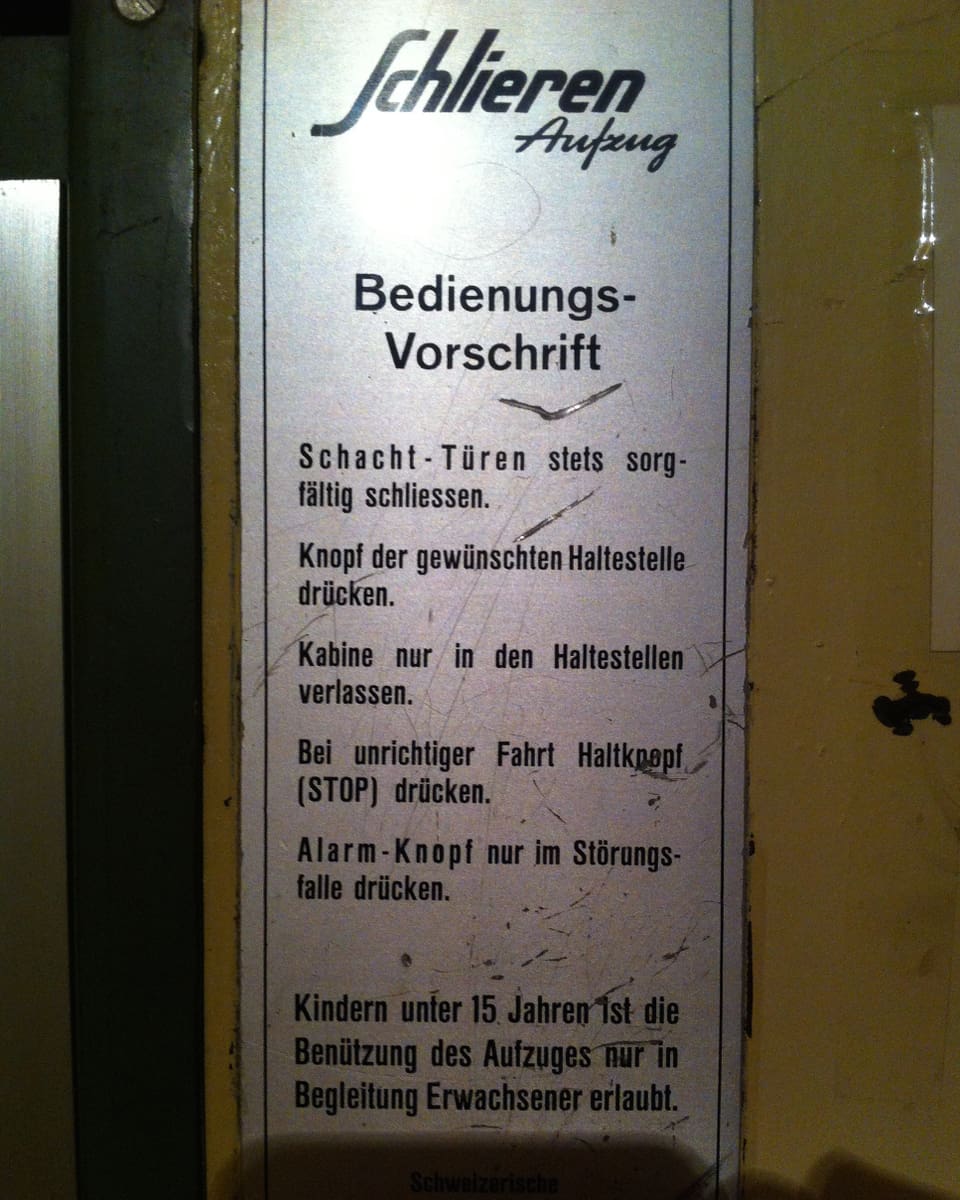 Schild an einer Aufzugstür mit "Bedienungsvorschrift"