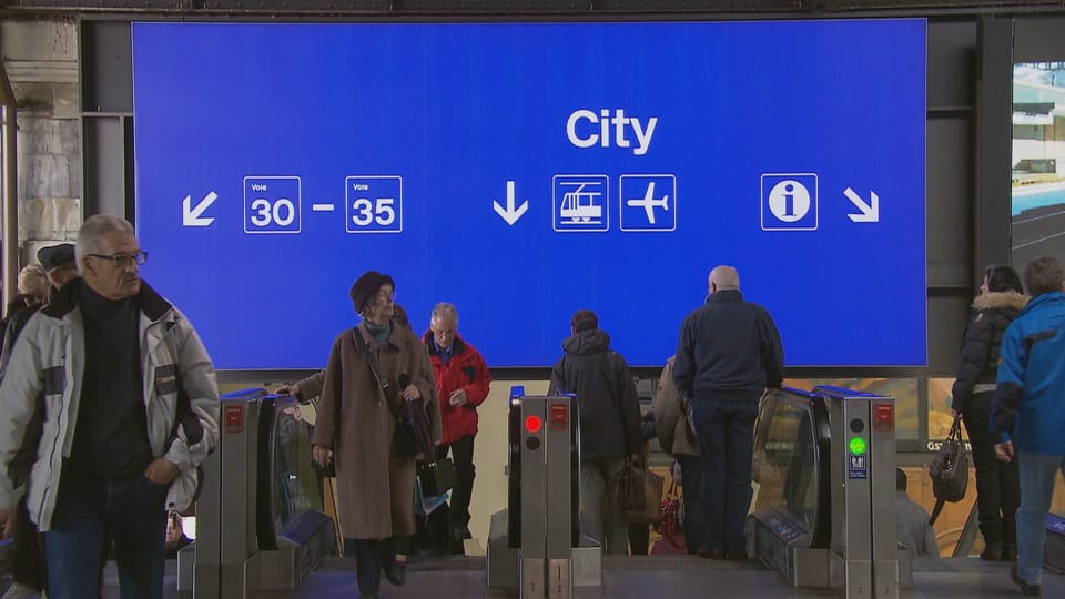 Eine grosse blaue Tafel mit verschiedenen Angaben wie City, Perronnummern und Flughafenzeichen im Basler Bahnhof.