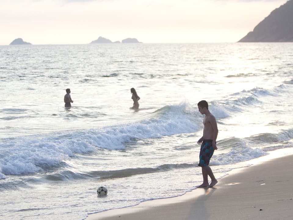 Drei Personen am Strand von Rio.