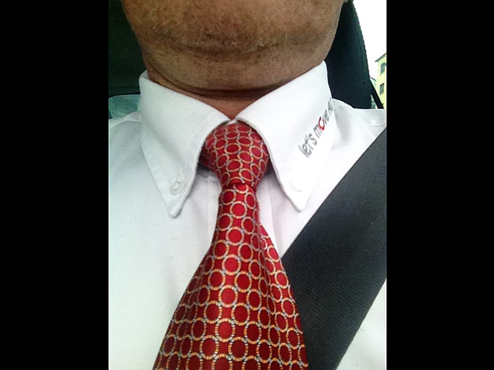 Rote Krawatte mit hellen Kreisen, weisses Hemd.