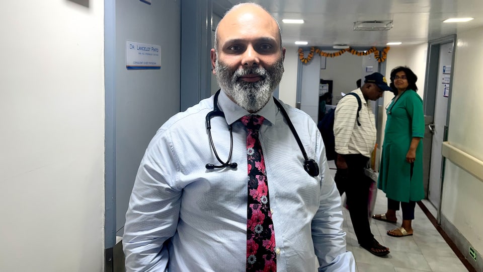 Portrait von Dr. Lancelot Pinto, Lungenarzt am Hinduja-Spital in Mumbai, in einem Spitalkorridor.