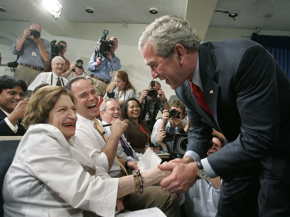 Präsident George W. Bush schüttelt Helen Thomas die Hand.