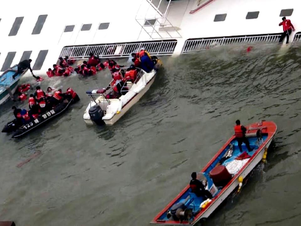 Rettungskräfte versuchen mit Booten, möglichst nah ans Schiff heranzukommen.