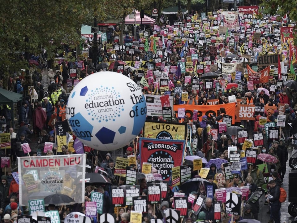 Menschen demonstrieren in London mit Plakaten.
