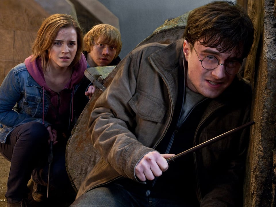 Hermine, Ron und Harry mit Zauberstab verstecken sich