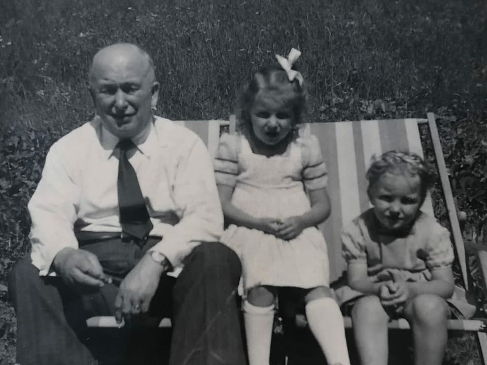 Zwei Mädchen und ihr Grossvater auf Liegestühlen.